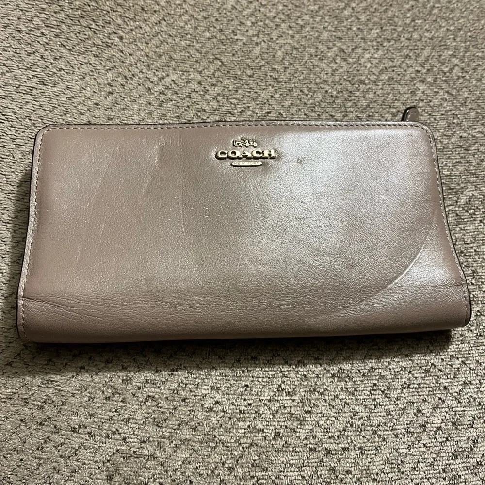 Coach wallet. Has some wear marks and wrinkles on outside of wallet.